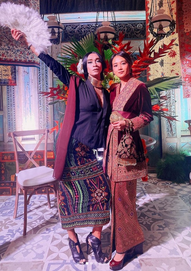 Seniman asal Bandung ini tak segan menata rambutnya dengan sanggul yang dipermanis bunga di bagian belakang. Sementara makeup bernuansa nude dengan sentuhan glamor memakai eyeshadow glitter. Foto: Instagram/@amingisback