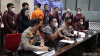 Indra Kenz awalnya memunggungi wartawan saat polisi menjelaskan kasus ini di Bareskrim Polri, Jakarta Selatan, Jumat (25/3/2022). Indra Kenz memakai baju tahanan warna oranye.