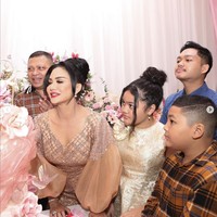 Krisdayanti tampil cantik dalam balutan gaun berwarna coklat dengan tangan model balon. Raul Lemos, Amora, dan Kellen pun mengenakan pakaian yang senada dengan Krisdayanti. Raul dan Kellen tampak mengenakan kemeja kotak-kotak berwarna coklat, sedangkan Amora tampil dalam balutan gaun berwarna emas. Foto: Instagram