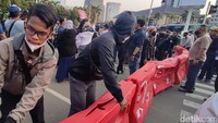 Sebagian peserta aksi PA 212 juga terlihat melemparkan botol mineral ke arah polisi. Tak lama setelah itu, polisi memasang pembatas jalan oranye.