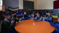 Anak-anak duduk di kelas mereka sebelum kelas dimulai di Sekolah Hari Desa Anak-anak Tibet.