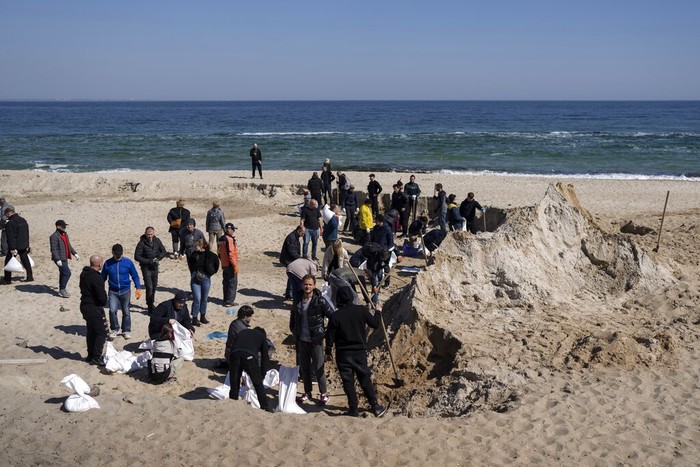 Volunteers at a sand beach fill sandbags to defend the city, in Odesa, southern Ukraine, on Wednesday, March 23, 2022. Western officials say that Ukrainian resistance has halted much of Russia's advance. (AP Photo/Petros Giannakouris)