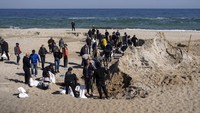 Rakyat Ukraina mengisi karung dengan pasir di Kota Odesa, di pantai Laut Hitam, Rabu (23/3/2022). (AP Photo/Petros Giannakouris)