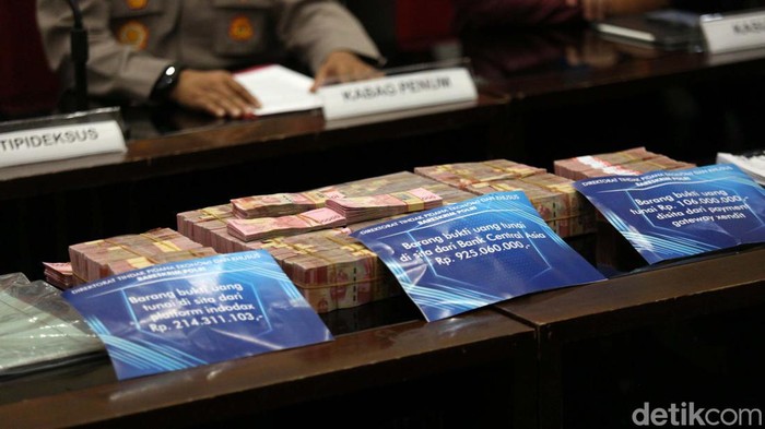 Polisi menyita sejumlah barang bukti dari tersangka affiliator Binomo Indra Kenz. Tumpukan uang serta mobil Tesla turut dihadirkan di Bareskrim Polri, Jakarta Selatan, Jumat (25/3/2022).