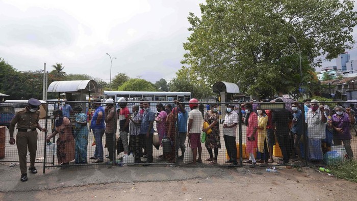 Sri Lankans wait in a queue to buy kerosene oil in Colombo, Sri Lanka, Friday, March 25, 2022. Earlier this month, Sri Lanka’s president requested people’s support by limiting electricity and fuel consumption to cope with the worst economic crisis in memory. (AP Photo/Eranga Jayawardena)