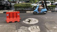 Hingga kini hanya ada road barrier berwarna oranye berada tepat di dekat sumur resapan yang ambles.