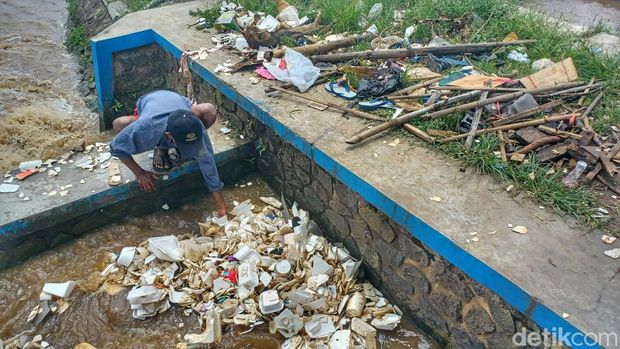 Cece tengah mengais sampah dengan menggunakan tangan di Sungai Cirasea