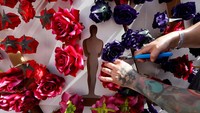Seorang pekerja menata bunga di sekitar potongan bentuk patung Oscar saat persiapan Academy Awards sedang berlangsung di Los Angeles, California, AS. REUTERS/Eric Gaillard