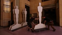 Pekerja memindahkan patung Oscar di sepanjang karpet merah saat persiapan Academy Awards berlanjut di Los Angeles, California, AS. REUTERS/Mike Blake