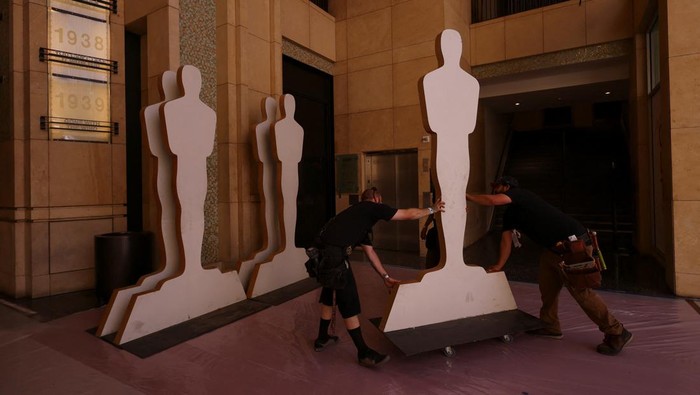 Workers roll out the red carpet on Hollywood Boulevard as preparations for the Academy Awards begin in Los Angeles, California, U.S., March 23, 2022. REUTERS/Mike Blake