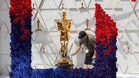 Seorang pekerja membersihkan patung Oscar saat persiapan Academy Awards sedang berlangsung di Los Angeles, California, AS. REUTERS/Eric Gaillard