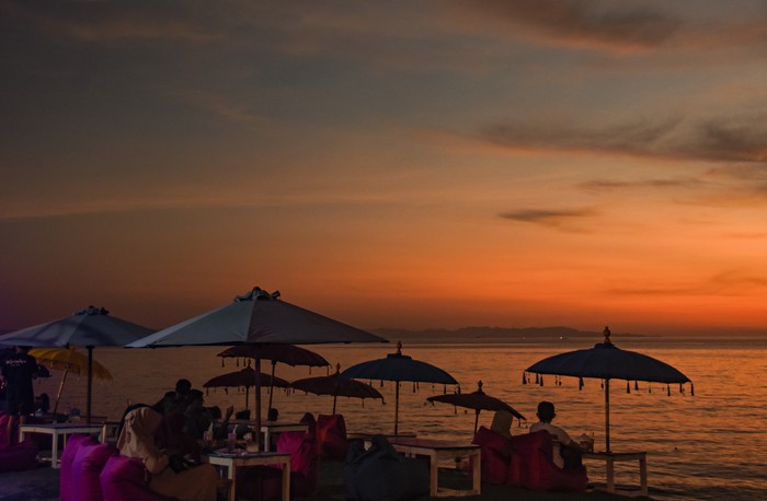 Pengunjung menikmati pemandangan matahari terbenam di pantai Tanjung Bias, Desa Senteluk, Kecamatan Batulayar, Lombok Barat, NTB, Sabtu (26/3/2022). Pantai Tanjung Bias yang berada di dekat kawasan wisata Senggigi tersebut setiap sore ramai dikunjungi warga serta wisatawan untuk menikmati kuliner khas Lombok dan panorama matahari tenggelam. ANTARA FOTO/Ahmad Subaidi/AWW.
