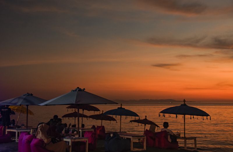 Pengunjung menikmati pemandangan matahari terbenam di pantai Tanjung Bias, Desa Senteluk, Kecamatan Batulayar, Lombok Barat, NTB, Sabtu (26/3/2022). Pantai Tanjung Bias yang berada di dekat kawasan wisata Senggigi tersebut setiap sore ramai dikunjungi warga serta wisatawan untuk menikmati kuliner khas Lombok dan panorama matahari tenggelam. ANTARA FOTO/Ahmad Subaidi/AWW.