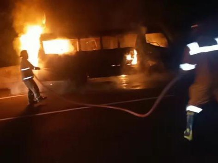 Petugas memadamkan api yang membakar minibus di jalan tol wilayah Desa Ngargosari, Kecamatan Ampel.