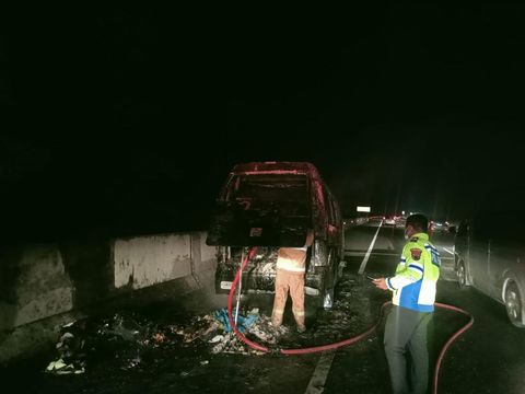 Petugas memadamkan api yang membakar minibus di jalan tol wilayah Desa Ngargosari, Kecamatan Ampel.