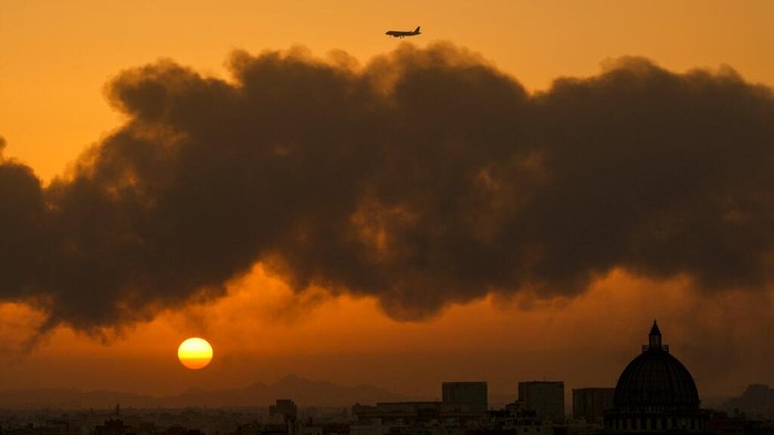 A cloud of smoke rises from a burning oil depot in Jiddah, Saudi Arabia, Friday, March 25, 2022. (AP Photo/Hassan Ammar)
