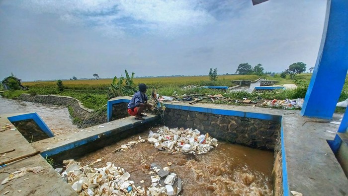 Salut! Pria Ini Inisiatif Bersihkan Tumpukan Sampah di Sungai Seorang Diri Demi tidak terjadi air yang meluap, seorang warga rela secara mandiri membersihkan tumpukan sampah yang tersendat di aliran irigasi sungai Cirasea, pintu lima, Jalan Sapan, Kecamatan Ciparay, Kabupaten Bandung. Warga tersebut adalah bernama Cece Supriyadi (60).