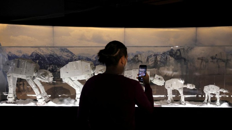 A person takes a selfie with a life-size figure of Darth Vader at 