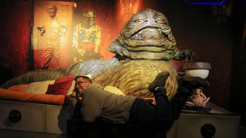 A person takes a selfie with a life-size figure of Darth Vader at 