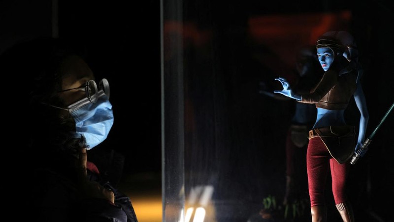 A person takes a selfie with a life-size figure of Darth Vader at 