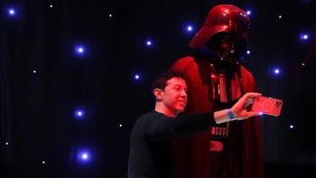 Seseorang berfoto selfie dengan sosok seukuran Darth Vader di The Fans Strike Back: The Largest Star Wars Fan Exhibition di Manhattan, New York City, AS, (24/3/2022).
