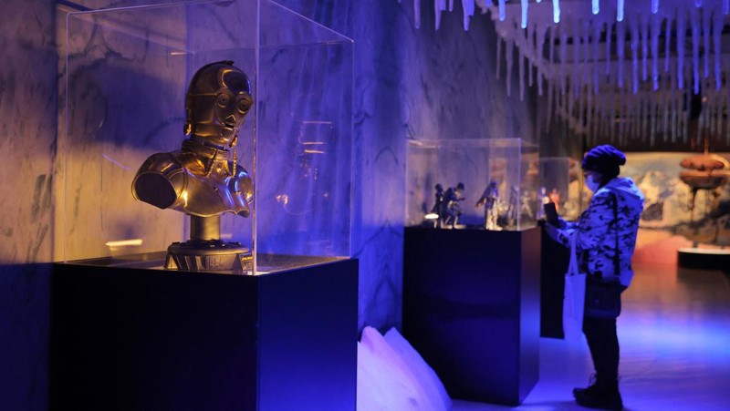 A person takes a selfie with a life-size figure of Darth Vader at 