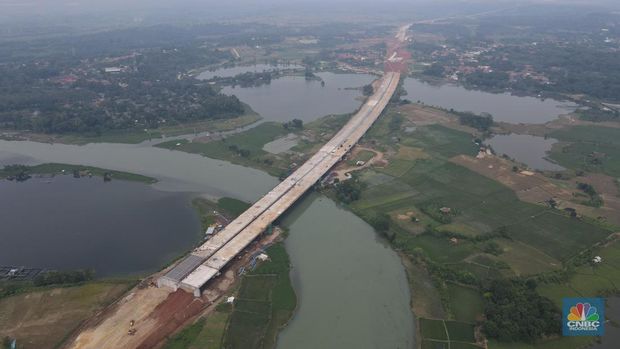 Foto udara pembangunan jembatan Tol Jakarta – Cikampek II Selatan yang melintasi Sungai Citarum di sekitar kawasan Curug Karawang Timur, Jawa Barat, Jumat (25/3/2022). Jalan Tol Jakarta-Cikampek II Selatan memiliki panjang 62 km yang terdiri atas 3 seksi. (CNBC Indonesia/ Andrean Kristianto)