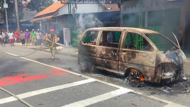 Petugas memadamkan minibus terbakar di jalur Pantura Pemalang, Minggu (27/3/2022).