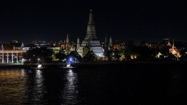 Pemandangan Kuil Fajar atau The Temple of Dawn saat lampu di kawasan kuil itu dimatikan saat peringatan Earth Hour di kawasan Bangkok, Thailand, Sabtu (26/3/2022). REUTERS/Chalinee Thirasupa.