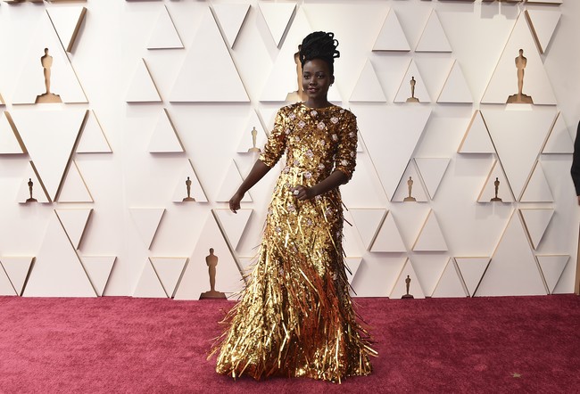 Selalu berani tampil berisiko, Lupita Nyongo memberikan vibe piala Oscar dengan gaun emas dari Prada yang bermandikan fringe nan jenaka. (Foto: Jordan Strauss/Invision/AP)