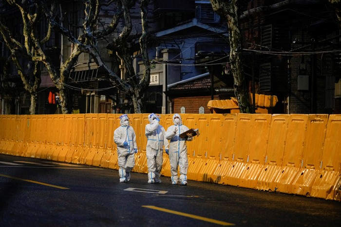 Police officers in protective suits keep watch at an entrance to a tunnel leading to the Pudong area across the Huangpu river, after traffic restrictions amid the lockdown to contain the spread of the coronavirus disease (COVID-19) in Shanghai, China March 28, 2022. REUTERS/Aly Song