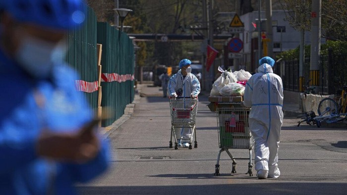 Residents line up for a coronavirus test inside barricaded residential buildings locked down for monitoring following a COVID-19 case detected in the area Monday, March 28, 2022, in Beijing. China began its largest lockdown in two years Monday to conduct mass testing and control a growing outbreak in its largest city of Shanghai as questions are raised about the economic toll of the nations 