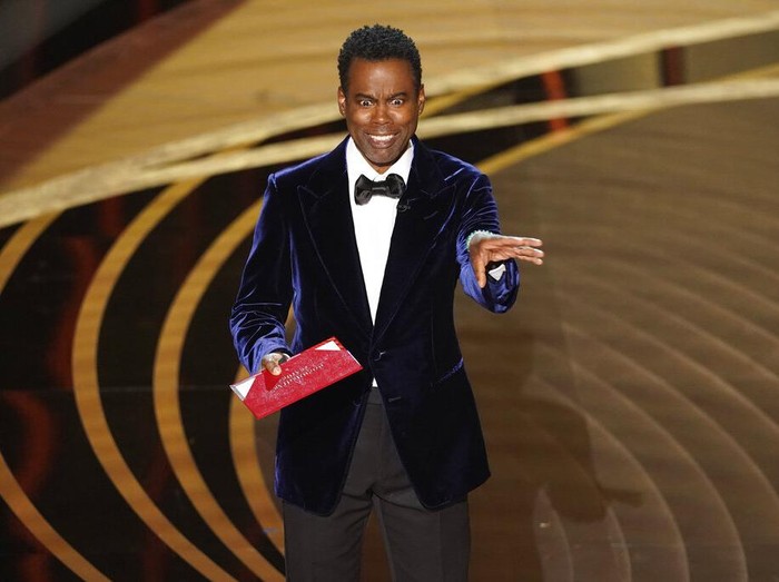 Chris Rock presents the award for best documentary feature at the Oscars on Sunday, March 27, 2022, at the Dolby Theatre in Los Angeles. (AP Photo/Chris Pizzello)
