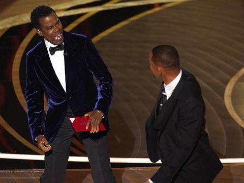 presenter Chris Rock, left, reacts after being hit on stage by Will Smith while presenting the award for best documentary feature at the Oscars on Sunday, March 27, 2022, at the Dolby Theatre in Los Angeles. (AP Photo/Chris Pizzello)