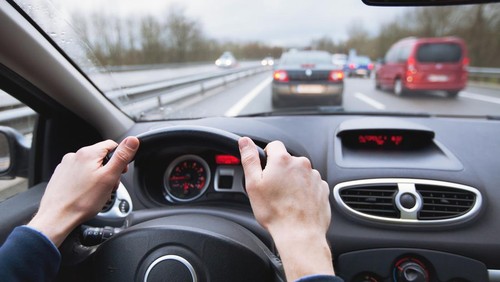 driving car on highway, close up of hands on steering wheel