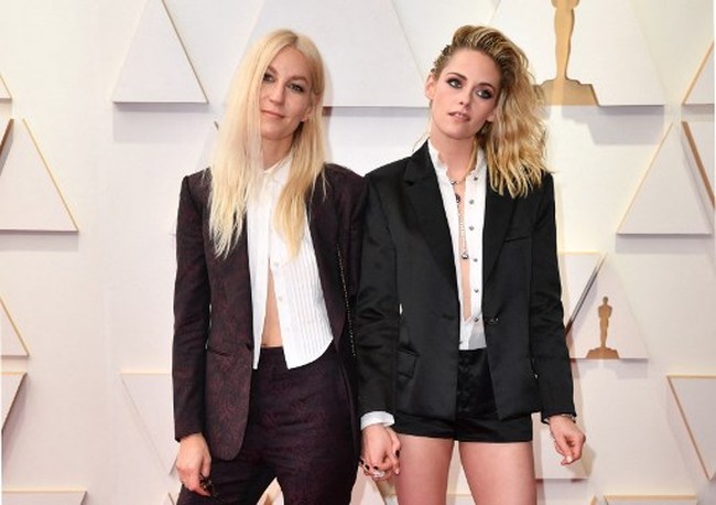 Kristen memadankan kemeja putihnya dengan blazer dan celana pendek hitam. Wanita yang menerima nominasi Oscars 2022 itu memakai high heels hitam untuk memberikan detail feminin pada penampilannya. Foto: AFP/ANGELA WEISS