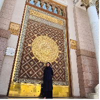 Berpose di depan pintu Masjid Nabawi, Madinah, Lulu Tobing tampil manglingi saat umrah dengan abaya dan hijab hitam. Foto: Dok. Instagram @lutob