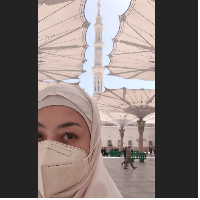 Berpose selfie dengan latar belakang keindahan payung-payung di Masjid Nabawi, Madinah, Lulu Tobing menuliskan harapan di keterangan fotonya. Dia berharap bisa kembali lagi ke Tanah Suci. Foto: Dok. Instagram @lutob