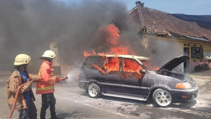Petugas memadamkan mobil yang terbakar di Karanganyar, Senin (28/3/2022).