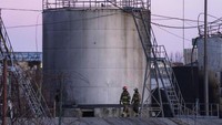 Petugas pemadam kebakaran bekerja di lokasi setelah serangan pertama yang melibatkan roket Rusia yang menghantam fasilitas minyak di kawasan industri di pinggiran timur laut Lviv, Ukraina, Minggu, (27/3/2022). (AP Photo/Nariman El-Mofty)