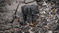 Sepotong mortir mencuat dari aspal di Stoyanka, Ukraina, Minggu, (27/3/2022). (AP Photo/Vadim Ghirda)