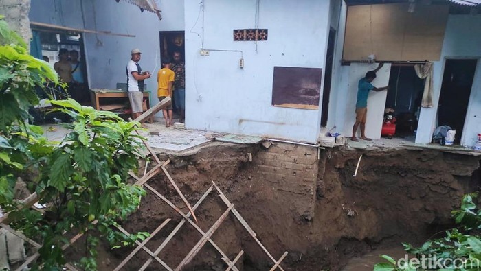 Rumah di Banyuwangi yang pondasinya ambrol dan dapurnya longsor tersapu sungai.