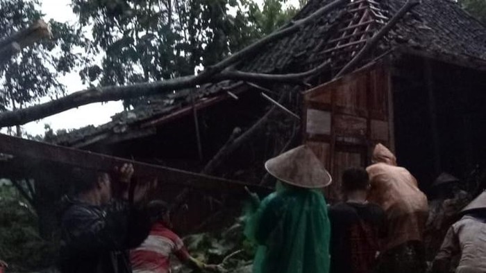 Warga membersihkan rumah yang tertimpa pohon tumbang di Eromoko, Wonogiri, Senin (28/3/2022).