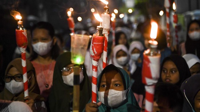 Warga memainkan alat musik saat mengikuti pawai obor di Palu, Sulawesi Tengah, Sabtu (26/3/2022). Pawai obor yang diikuti ratusan umat muslim tersebut dalam rangka menyambut bulan suci Ramadan 1443 H. ANTARA FOTO/Mohamad Hamzah/aww.