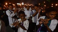 Warga memainkan alat musik saat mengikuti pawai obor di Palu, Sulawesi Tengah, Sabtu (26/3/2022). 