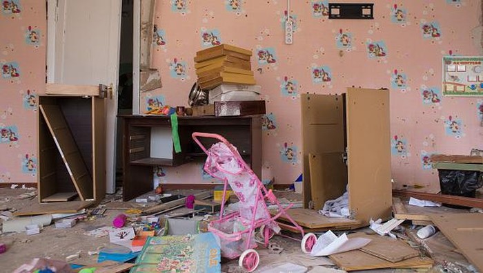 TK di Ukraina Dulunya Penuh Keceriaan, Kini Hancur Berantakan BYSHIV, UKRAINE - MARCH 27: Svitlana Hrabovska, 50, the head teacher of the kindergarten, which got destroyed as a result of a rocket strike in the area earlier, removes the broken glass from the window on March 27, 2022 in Byshiv, Ukraine. The rocket hit the kindergarten on March 2 and 3. The kindergarten used to accommodate 120 children from the area, they were evacuated long before the strikes. Ukraine's military says it has made territorial gains in the wider Kyiv region, after Russia's advance on the capital had largely stalled in recent weeks. But intermittent shelling and missile strikes persist. (Photo by Anastasia Vlasova/Getty Images)