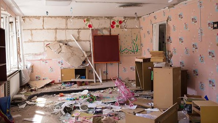 BYSHIV, UKRAINE - MARCH 27: Svitlana Hrabovska, 50, the head teacher of the kindergarten, which got destroyed as a result of a rocket strike in the area earlier, removes the broken glass from the window on March 27, 2022 in Byshiv, Ukraine. The rocket hit the kindergarten on March 2 and 3. The kindergarten used to accommodate 120 children from the area, they were evacuated long before the strikes. Ukraine's military says it has made territorial gains in the wider Kyiv region, after Russia's advance on the capital had largely stalled in recent weeks. But intermittent shelling and missile strikes persist. (Photo by Anastasia Vlasova/Getty Images)