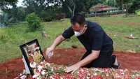 Membawa sebotol air, Vicky Prasetyo terlihat menyiram makam. (Foto: Palevi/detikcom)