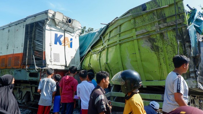 Sebuah mobil tertimpa papan reklame yang ambruk akibat kecelakaan di perlintasan Kereta Api, di Kayukalek, Padang, Sumatera Barat, Selasa (29/03/2022). Kecelakaan antara Kereta Api Jurusan Pariaman dengan sebuah truk itu menyebabkan papan reklame ambruk dan sebuah mobil rusak, sedangkan akses jalan tertutup sementara. ANTARA FOTO/Iggoy el Fitra/foc.