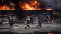 Petugas pemadam kebakaran bekerja untuk memadamkan api di sebuah gudang yang terkena tembakan Rusia di Kharkiv, Ukraina, Senin (28/3/2022) waktu setempat.  